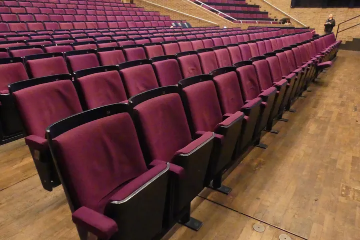 Theater-/Saalbestuhlung, 3 Reihen à 28 Sitzplätze, gepolsterte Klappsitze, pink/schwarz